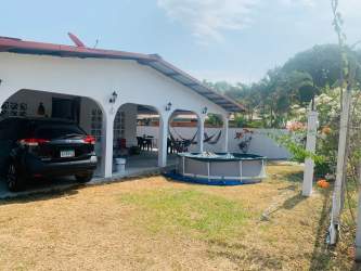 Single-story house with red roof, carport, above-ground pool, and garden Nueva Gorgona Panama