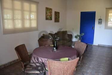 Dining and living area with tile floors, wicker chairs, arches in Playa Malibu beach house