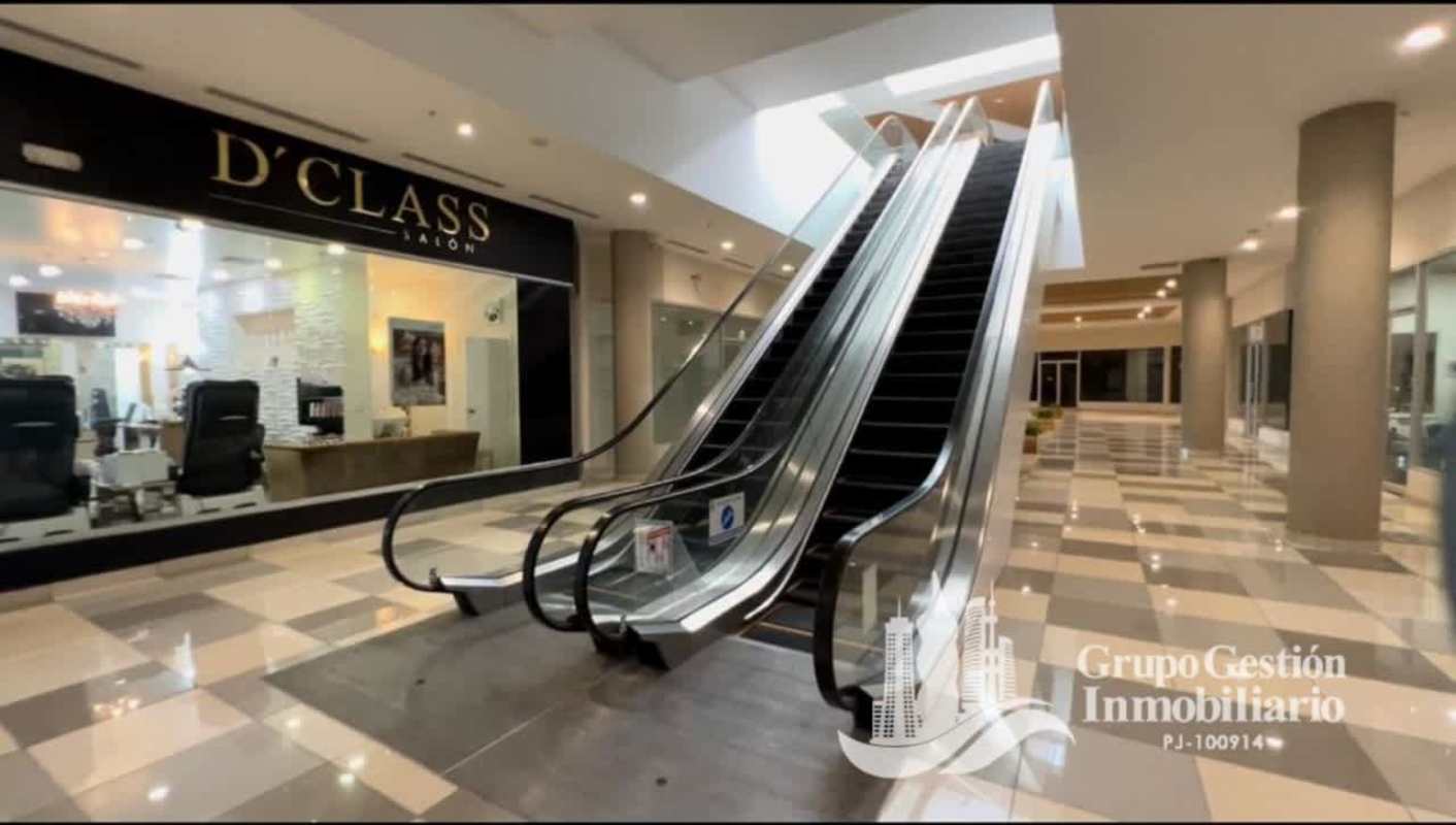 Indoor mall corridor with escalators glass storefronts at Paseo Albrook Panama