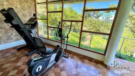 Cozy living space with large windows overlooking green mountains in San Carlos Panama