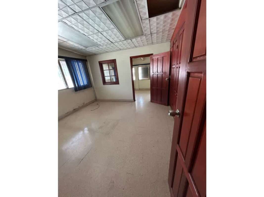 Interior staircase and hallway leading to bathroom with wood railing commercial house San Francisco Panama