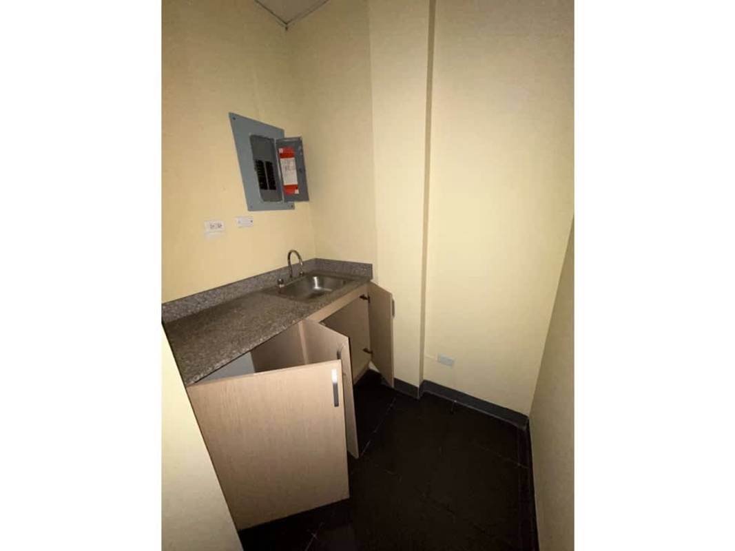 Small empty office room with beige walls, dark flooring in business center Panama City