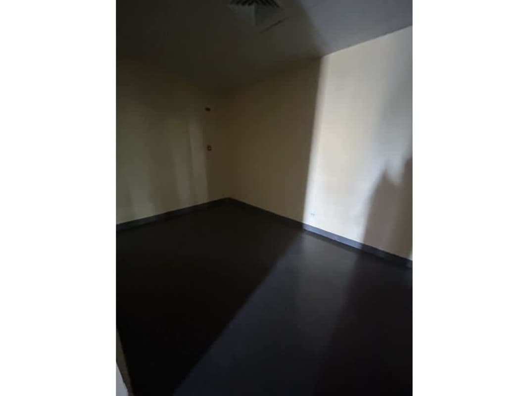 Minimalist empty office space beige walls dark flooring Panama commercial lease