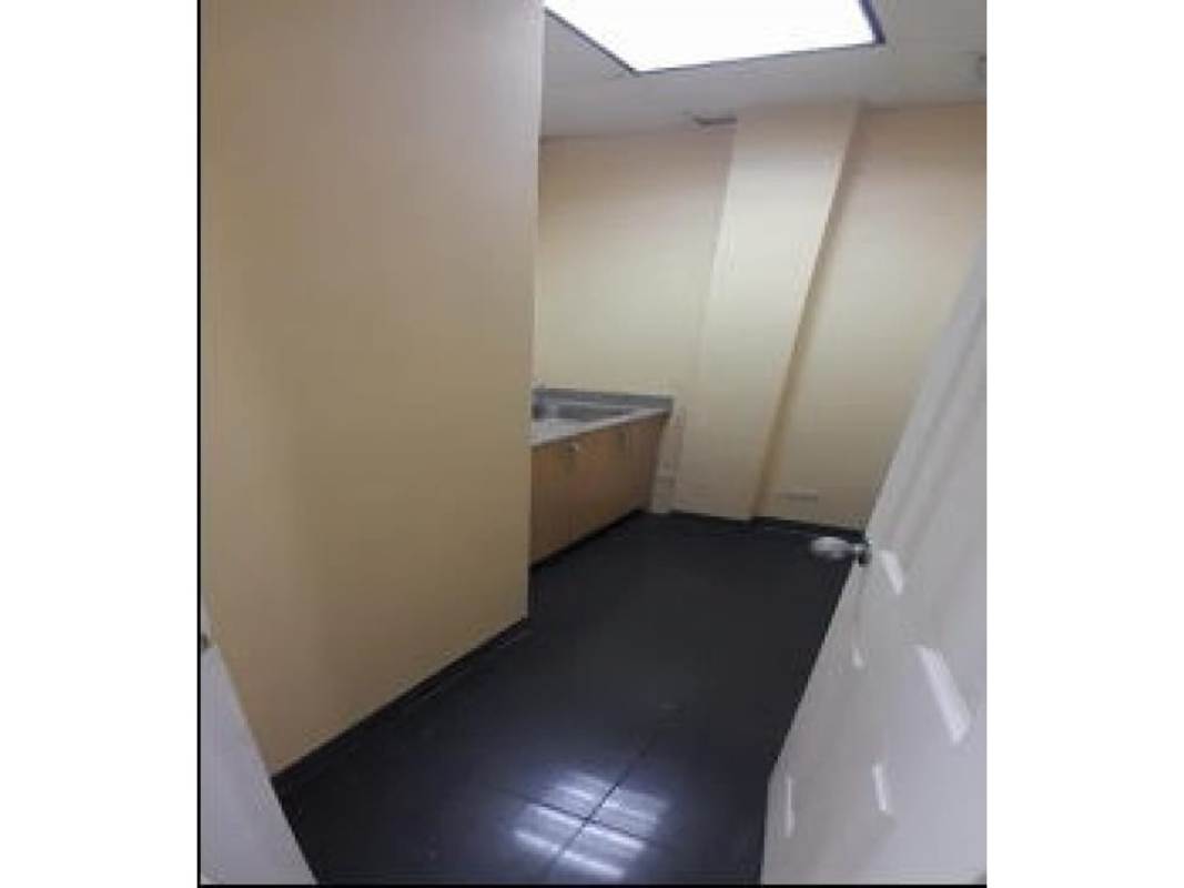 Small kitchenette or utility room with beige walls, dark floor and stainless sink in a Panama office