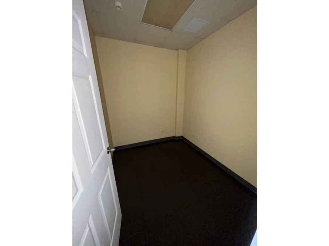 Empty small private office with drop ceiling and dark flooring Panama City