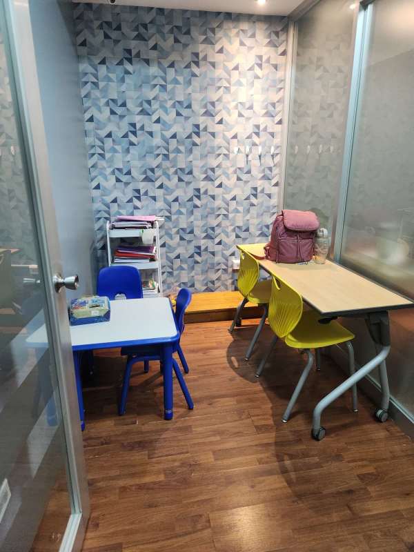 Bright study classroom with blue table, geometric accent wall at PH BICSA Financial Center Panama