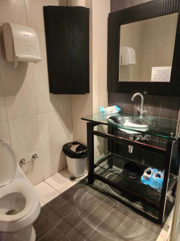 Commercial bathroom with glass sink and black mirror frame inside BICSA Tower Panama