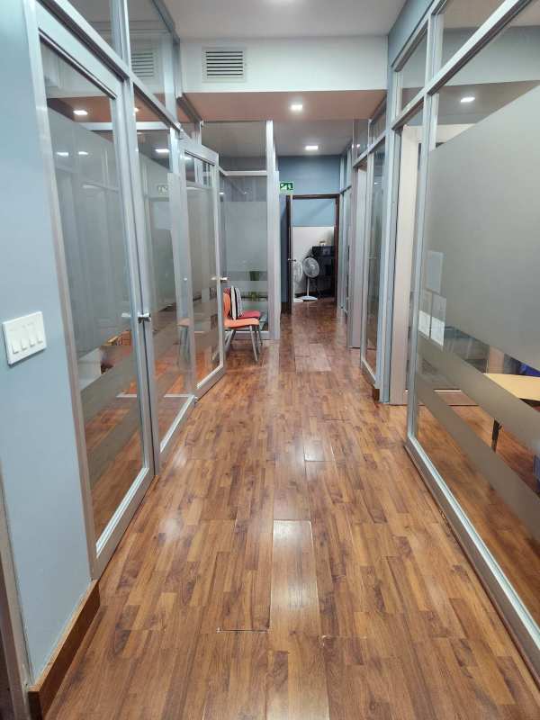Contemporary office corridor with glass walls and wood floors PH BICSA Financial Center Panama