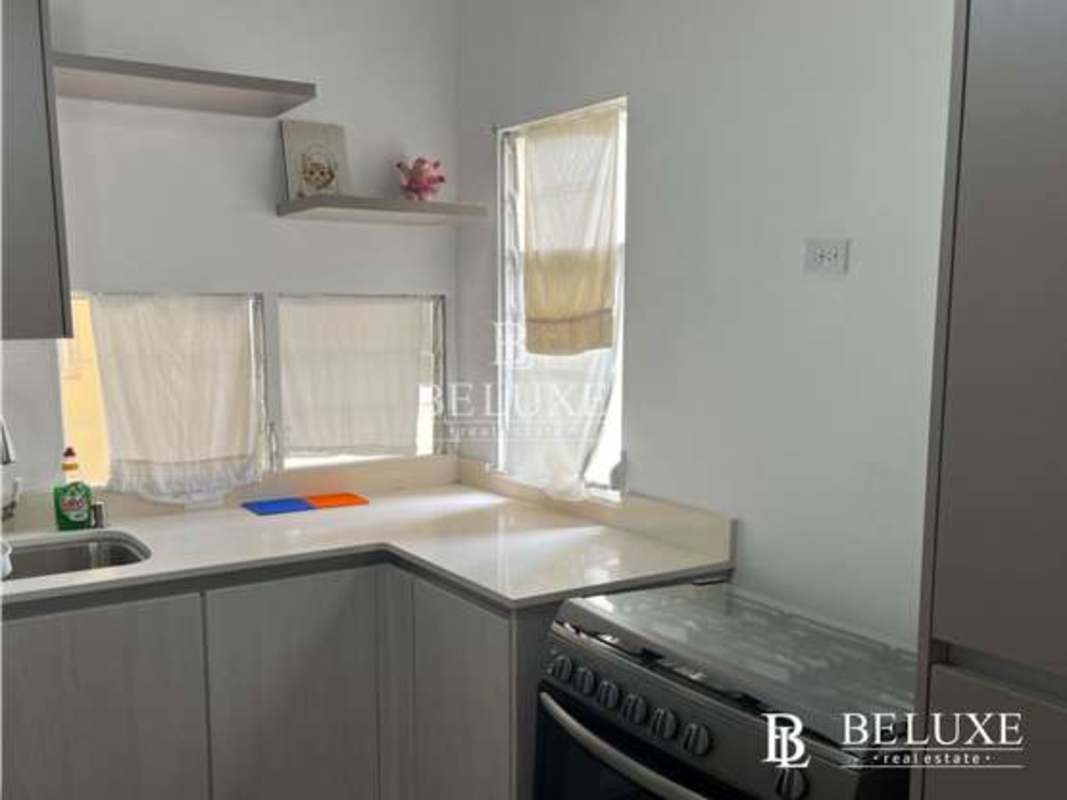 Minimalist kitchen with L shape counter, gas stove, window and stainless sink PH Amador Hill Panama