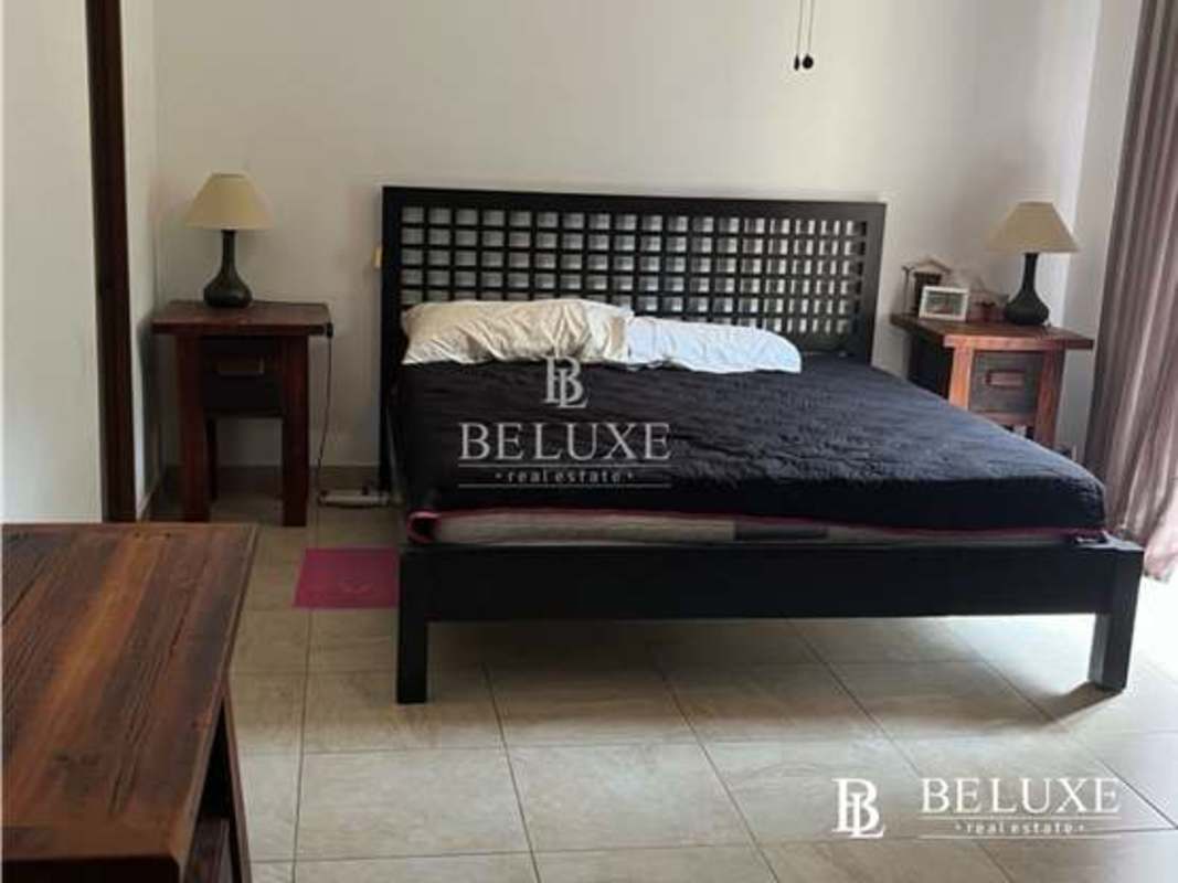 Master bedroom with large bed, nightstands, en suite bathroom and neutral decor PH Amador Hill