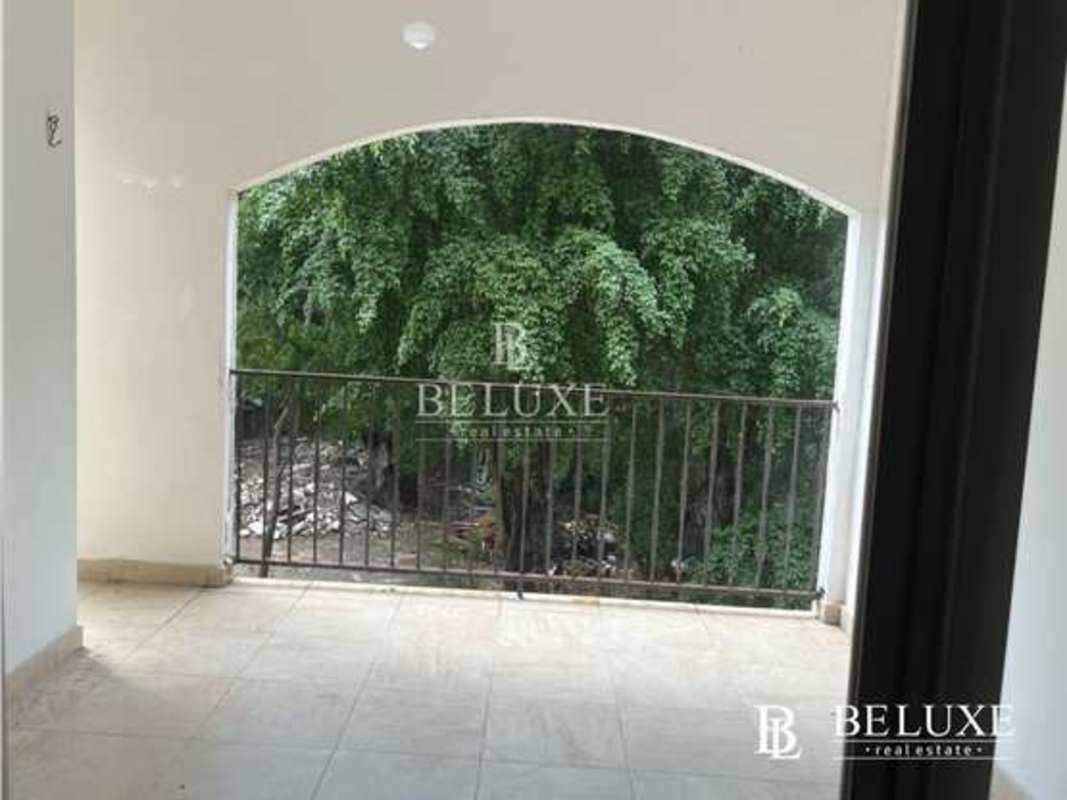 Covered tiled balcony with metal railing overlooking green trees PH Amador Hill Panama