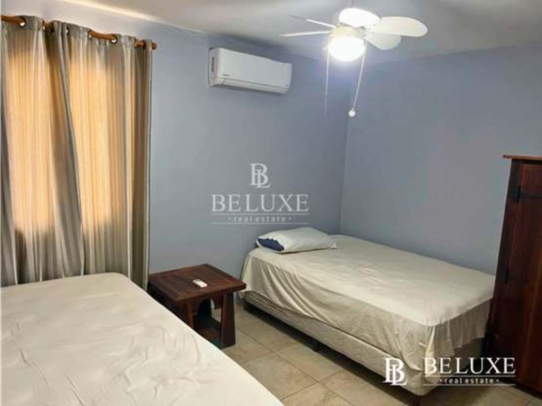 Bedroom furnished with twin beds, AC, window and neutral decor PH Amador Hill Panama