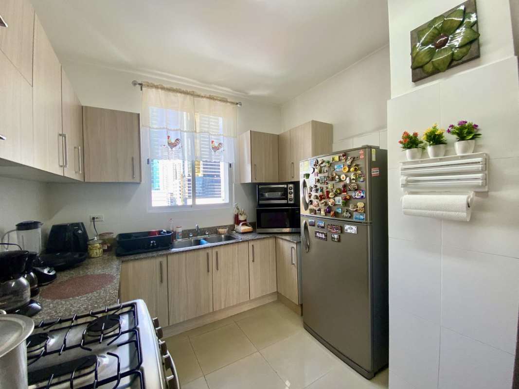 Light wood kitchen with granite countertop, window, and stainless appliances in PH Galeria Uno Obarrio
