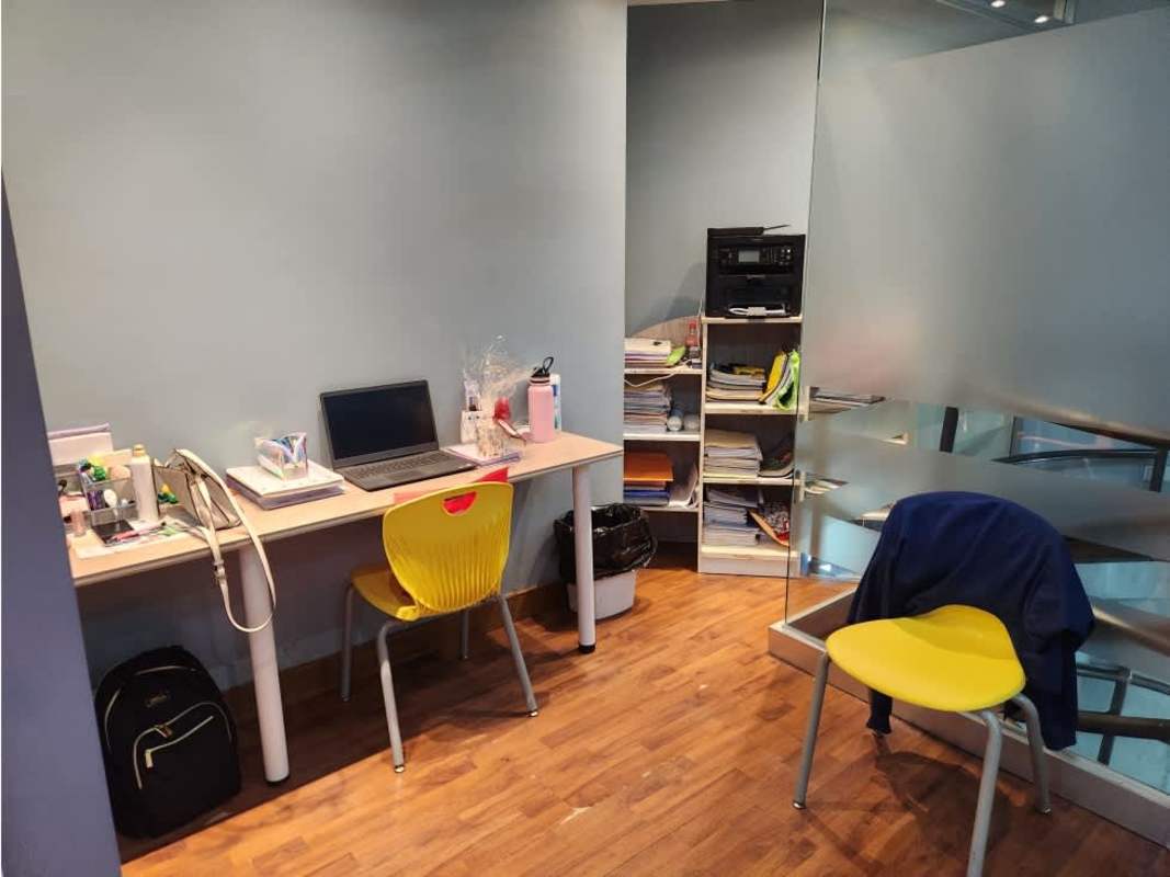 Small office workspace with wooden flooring blue walls glass partition in Panama City commercial building