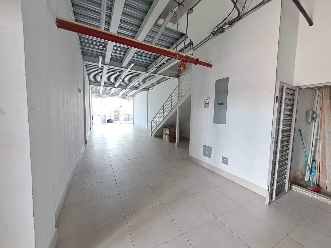Two-story industrial style commercial interior metal ceiling exposed piping staircase Plaza Llano Bonito Panama