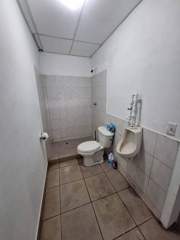 Utility bathroom with shower area, urinal and tiles in Ciudad Radial warehouse Panama