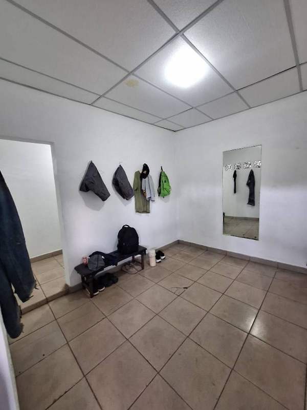 Simple staff changing room with tiled floor, wall mirror and hooks Ciudad Radial Panama