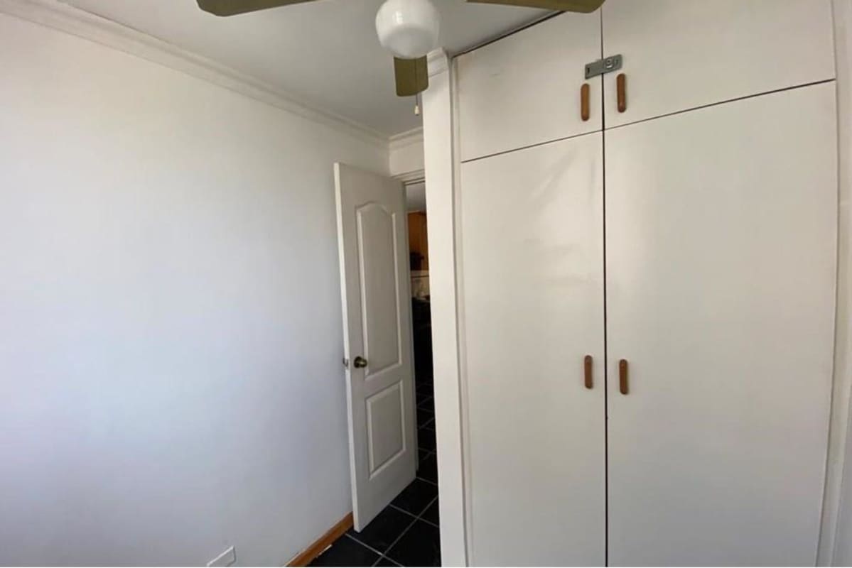 Minimalist bedroom with closet, ceiling fan, black tile floor PH Torres Mar del Sur Panama City
