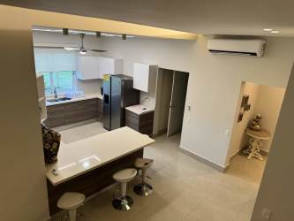 Covered terrace overlooking lush gardens and partial ocean at Villa Mar Casamar Panama