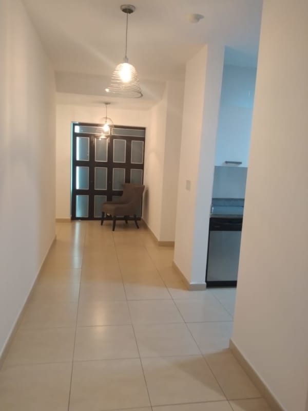 Entrance hallway leading to living room with glass walls city views PH Water on the Bay Panama