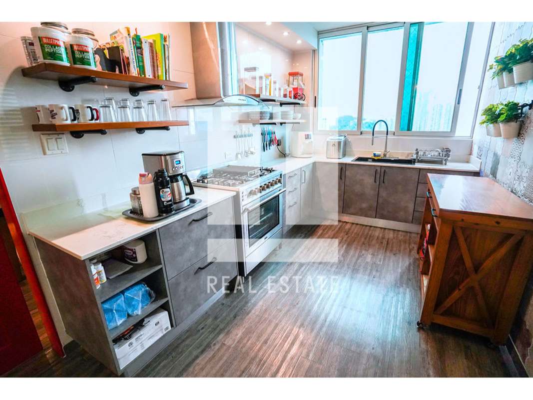 Mezzanine loft den overlooking penthouse living room with decorative stairs at PH Trinity Tower Panama City