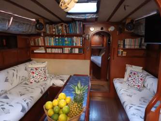 Bedroom cabin with porthole and wood paneling inside Amel Maramu sailboat in Puerto Lindo Marina Panama