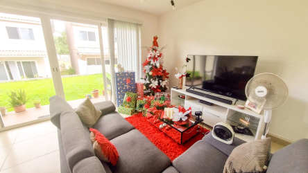 Spacious living room with large sliding doors leading to backyard in Costa Verde home