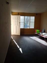 Living room with window, door, ceiling tiles, minimal furnishings Villa Nazareth Panama