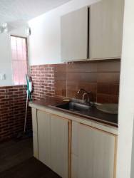 Simple kitchen with brown backsplash, brick accent, basic cabinetry in Villa Nazareth Puerto Caimito