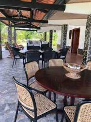 Large covered patio with stone pillars, tiled floor, furniture, garden views in Penonomé country villa