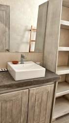 Rustic bathroom with vessel sink wooden vanity shelving at El Ciruelo Residences Playa Venao
