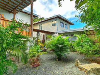Two-story tropical home with garden balcony wood accents at El Ciruelo Playa Venao Panama