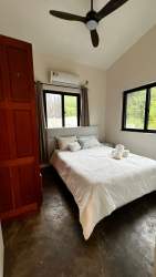 Modern open-plan kitchen and living room with yellow cabinets AC large glass door in Playa Venao Panama