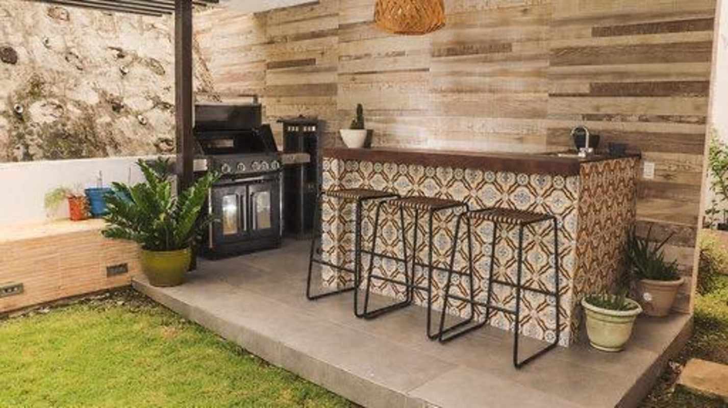 Outdoor patio with tiled bar, grill station, and potted plants Fuente del Fresno luxury home Panama