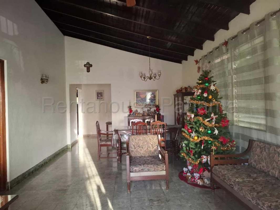 Traditional living dining room with vaulted wood ceiling, wooden furniture and large windows in Miraflores Betania Panama