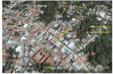 Fenced entrance to interior lot lined with greenery and mature trees in Penonomé