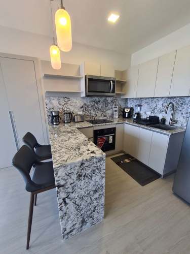 Open kitchen area with refrigerator, stove and cabinets in PH Las Acacias Juan Díaz Panama