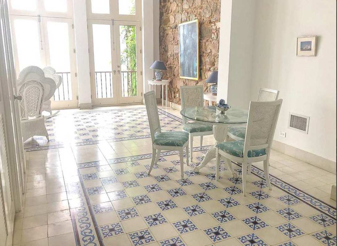 Bright dining room with stone accent wall, patterned tile floor and glass dining table Casco Viejo