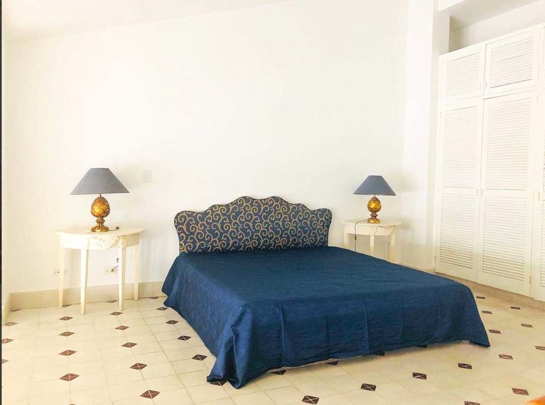 Large bedroom with navy blue accents, patterned headboard, built-in closets Casco Viejo apartment
