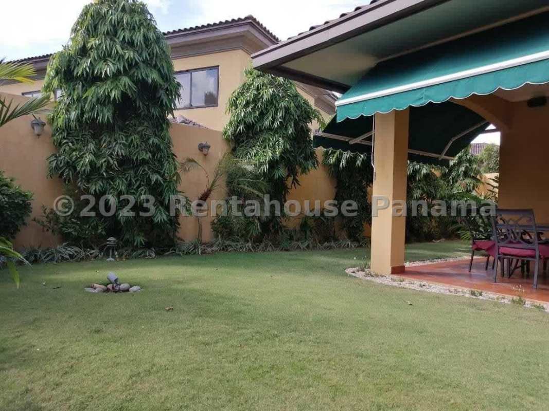 Backyard with green lawn, covered terrace, outdoor seating, landscaped garden Costa del Este Panama