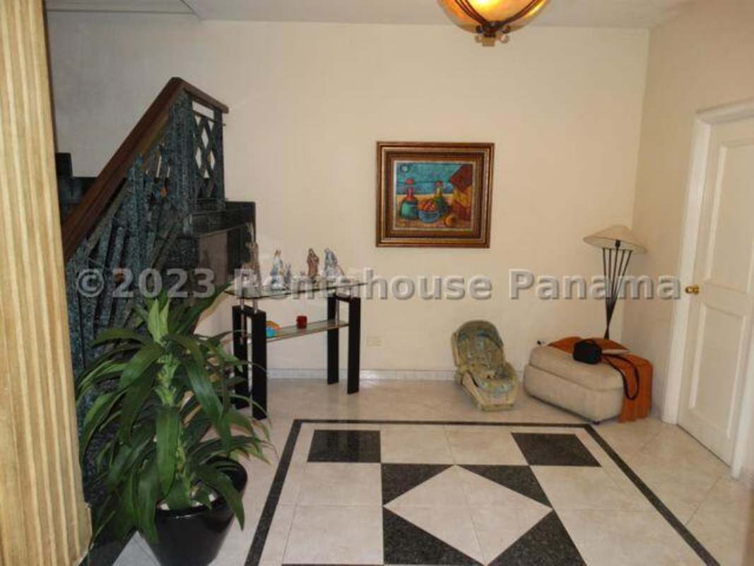 Elegant dining area with wooden table, chandelier, traditional decor in Betania Panama house