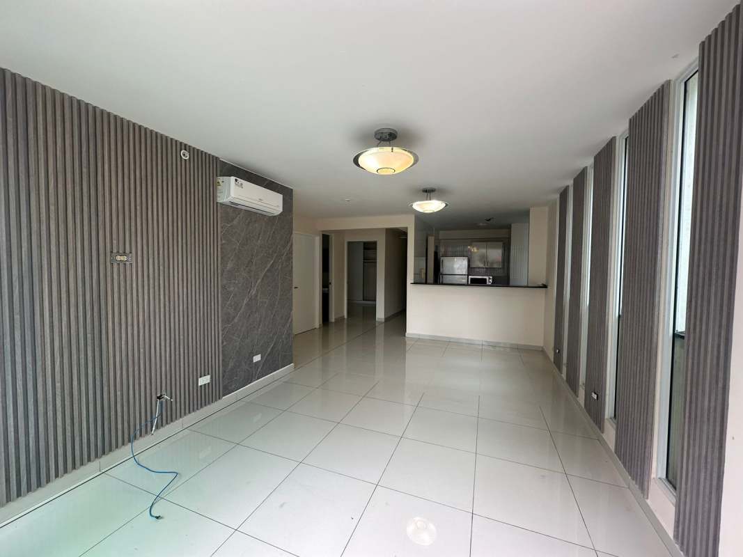 Spacious living room with marble accent wall, balcony door, and panoramic views in PH Bela Vita Panama City
