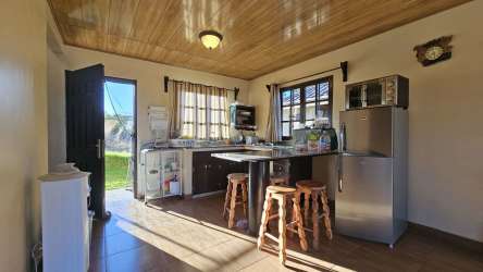 Open kitchen with wood ceilings, breakfast bar and rustic finishes countryside house Chiriqui Panama