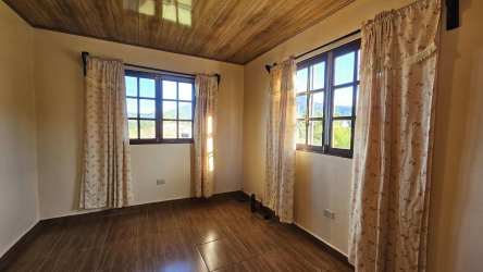 Bright rustic bedroom with wood ceiling, tile floors, large windows Tierras Altas Panama