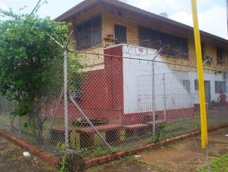 Side perspective of two-level house with fencing and external stairs Colón Panama