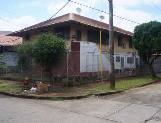 Entrance view with security fence and yard in two-level house in Colón Panama