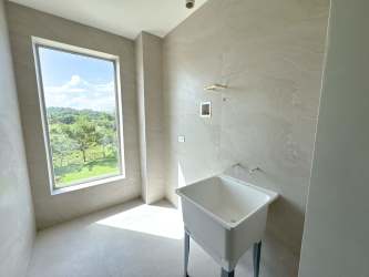 Spacious laundry room with large window overlooking greenery Playa Escondida condo Panama