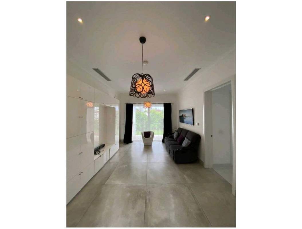 Spacious family room with modern furniture and floor-to-ceiling windows in luxury villa Santa Maria Panama