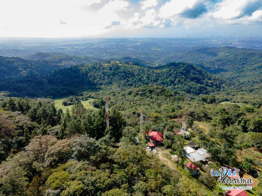Aerial mountain land Cerro Azul with dense forest and telecom tower structures Panama real estate