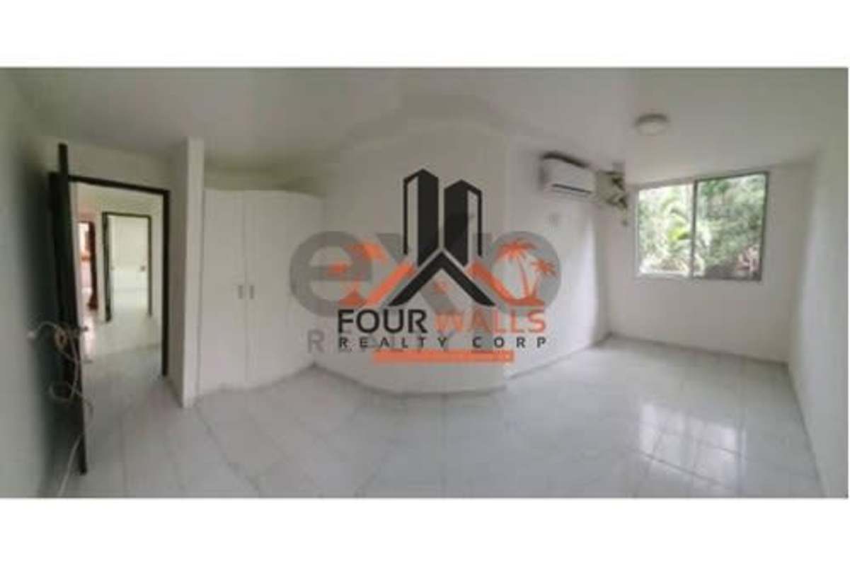 Bedroom with split air conditioner, built-in wardrobe, and large window at PH Altos de Bella Vista Panama City